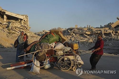 이스라엘의 공격으로 폐허가 된 가자시티 거리를 지나는 피란민 [AP 연합뉴스 자료사진. 재판매 및 DB 금지]
