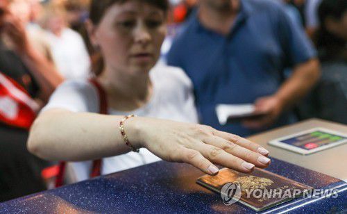 공항 발권 카운터에서 여권을 보여주는 러시아 시민[타스 연합뉴스 자료사진. 재판매 및 DB 금지]