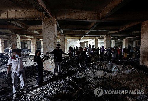 네팔의 불탄 슈퍼마켓(카트만두 로이터=연합뉴스) 14일(현지시간) 네팔 수도 카트만두의 한 불탄 슈퍼마켓에서 사람들이 잔해를 정리하고 있다.