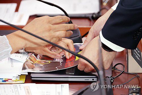 피켓 철거 거부하는 국민의힘 의원들(서울=연합뉴스) 김주성 기자 = 22일 서울 여의도 국회 법제사법위원회에서 열린 '건진법사 관봉권 띠지' 분실 관련 검찰개혁 입법청문회에서, 국민의힘 나경원 의원 등 위원들이 노트북에 붙인 '정치공작, 가짜뉴스 공장, 민주당!'이라고 적힌 피켓을 경위 들이 떼려하자 거부하고 있다. 2025.9.22 utzza@yna.co.kr