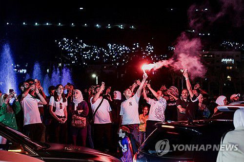 시리아 시민들(다마스쿠스 로이터=연합뉴스) 24일(현지시간) 시리아 시민들이 야외에 모여 알샤라 대통령의 유엔총회 연설을 생중계로 지켜보며 불꽃놀이를 하고 있다. 2025.9.25 photo@yna.co.kr
