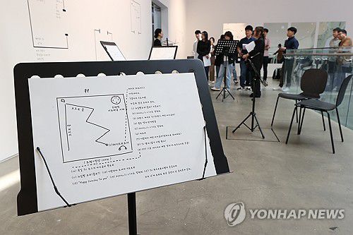 백남준의 텍스트 악보(서울=연합뉴스) 강민지 기자 = 1일 서울 관악구 서울대학교미술관에서 열린 기획전 '차원확장자: 시ㆍ이미지ㆍ악보ㆍ코드' 간담회에서 참석자가 작품을 둘러보고 있다.  2025.10.1 mjkang@yna.co.kr