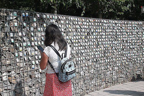 입양인 700명 이름표가 걸려있는 '기억의 벽'2025년 6월 경기 파주 엄마품동산 내 가장자리에 있는 기억의 벽에서 한 입양인이 입양인들의 이름표를 들여다보고 있다. 해외입양인들을 위한 '기억과 치유의 공간'인 엄마품동산은 8년여의 준비 끝에 6월 공식 개장했다.  [연합뉴스 사진]