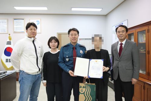 보이스피싱 추가 피해를 막은 주민 A씨가 경찰서장 명의 감사장을 받는 모습. [서울 양천경찰서 제공. 재판매 및 DB 금지]