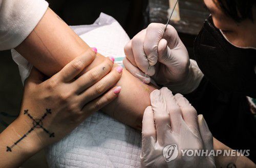 2021년 4월 22일 서울의 한 작업실에서 타투이스트가 바늘로 작업을 하고 있다.[연합뉴스 자료사진]