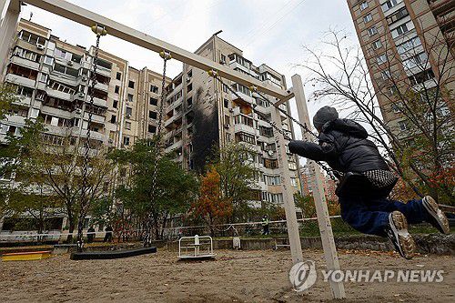 러시아 공격으로 부서진 아파트 앞에서 그네타는 아이[로이터=연합뉴스 자료사진]