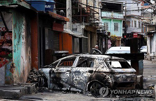 28일(현지시간) 브라질 갱단 해체 작전지 내 불에 탄 자동차[리우데자네이루 로이터=연합뉴스. 재판매 및 DB 금지]