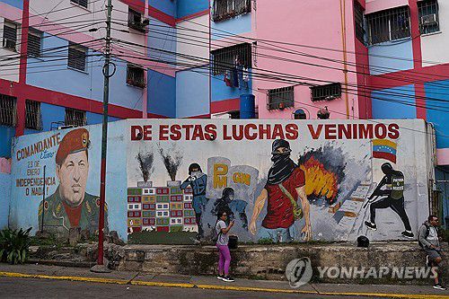 11일(현지시간) 베네수엘라 좌파 지도자 우고 차베스 벽화(왼쪽)와 투쟁 의지를 고취하는 글귀[카라카스 AP=연합뉴스. 재판매 및 DB 금지]