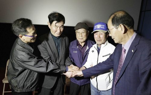 45년 만에 맞잡은 손영화 '1980 사북' 특별상영회가 열린 지난 4월 20일 영월시네마에서 사북 항쟁동지회 명예회장 이원갑(사진 왼쪽 두 번째) 씨가 진문규(맨 오른쪽)·이종환(오른쪽 두 번째)·최병주(가운데) 등 전 영월경찰서 소속 경찰들의 손을 잡고 화해하고 있다. [영화사 느티 제공.재판매 및 DB 금지]