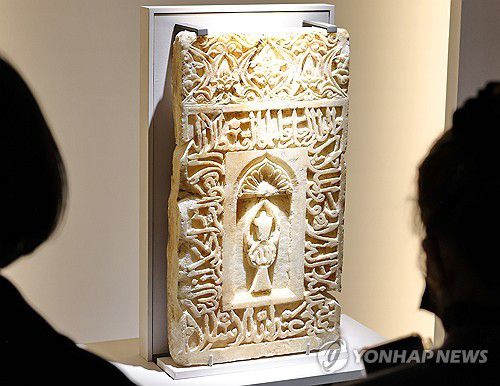 메카 방향 표시하는 미흐랍 석판(서울=연합뉴스) 이재희 기자 = '이슬람 미술, 찬란한 빛의 여정' 전시가 열린 21일 서울 국립중앙박물관 상설전시관에서 취재진 및 관계자들이 모스크에서 메카 방향을 표시하는 벽감인 미흐랍 석판을 살펴보고 있다. 이 전시는 2026년 10월 11일까지 열린다. 2025.11.21 scape@yna.co.kr