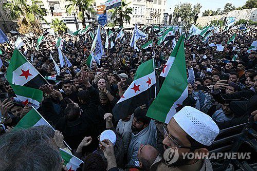 '아사드 축출 기념'(다마스쿠스 AFP=연합뉴스) 지난달 28일(현지시간) 시리아 시민들이 알아사드 독재정권 축출 1주년을 기념하며 행진 중이다. 2025.12.5 photo@yna.co.kr