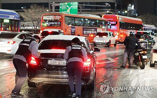 차 미는 경찰(서울=연합뉴스) 이진욱 기자 =  서울·인천·경기·강원 등 4개 시도에 대설특보가 발효된 4일 서울 마포구 홍대 인근 제설작업이 완료되지 못한 도로에서 경찰들이 언덕길 차를 밀고 있다. 2025.12.4 cityboy@yna.co.kr