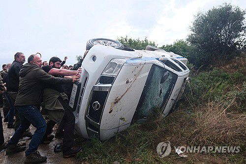 경찰차 전복하는 그리스 농민 시위대[AFP 연합뉴스 자료사진./ 재배포 및 DB 금지]