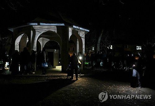 13일(현지시간) 러시아 공습 후 우크라이나 남부 도시 모습. 주민들이 어둠 속에서 식수를 받기 위해 줄을 서 있다.[로이터 연합뉴스. 재판매 및 DB 금지]