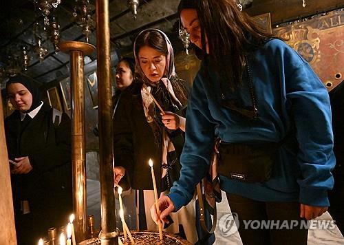 베들레헴 성당의 촛불(베들레헴 <팔레스타인 서안지구> 2025년 12월 23일 예수 탄생지로 알려진 팔레스타인 서안지구 베들레헴의 예수 탄생 기념 성당에서 사람들이 촛불을 켜고 있다. (Photo by Debbie Hill/ UPI) 2025.12.26.