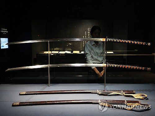 이순신의 글씨가 있는 장검(서울=연합뉴스) 강민지 기자 = 27일 서울 용산구 국립중앙박물관에서 '우리들의 이순신' 전시 언론공개회에서 참석자가 '이순신 장검'을 둘러보고 있다. 충무공 탄신 480주년과 광복 80주년을 맞아 선보이는 전시는 다음 달 4일까지는 무료 개방한다. 2025.11.27  mjkang@yna.co.kr