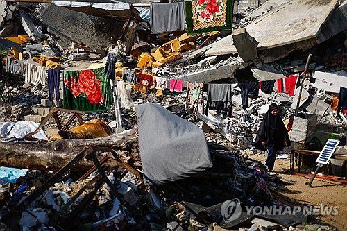 파괴된 건물 잔해 사이 걸어가는 팔레스타인 소녀[로이터 연합뉴스 자료사진. 재판매 및 DB 금지]