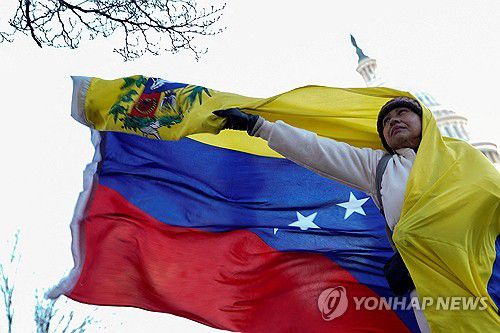 15일(현지시간) 미국 국회의사당 앞에서 베네수엘라 국기 펼치는 여성[워싱턴 로이터=연합뉴스. 재판매 및 DB 금지]