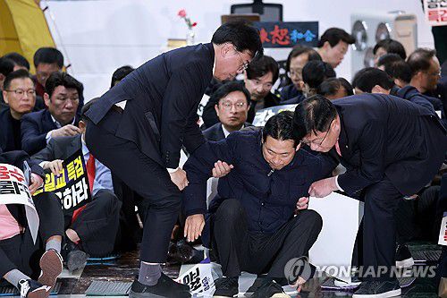 부축 받으며 일어서는 국민의힘 장동혁 대표(서울=연합뉴스) 신현우 기자 = 국민의힘 장동혁 대표가 19일 국회 로텐더홀에서 열린 더불어민주당에 통일교·공천헌금 '쌍특검' 수용을 요구하는 규탄대회를 마치고 송언석 원내대표와 정점식 정책위의장의 부축을 받으며 일어서고 있다. 2026.1.19 nowwego@yna.co.kr