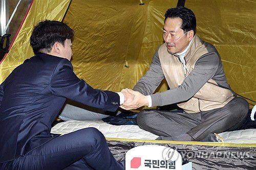 인사하는 장동혁-이준석(서울=연합뉴스) 배재만 기자 = 통일교·공천헌금 '쌍특검' 수용을 요구하며 단식 7일 차를 맞은 국민의힘 장동혁 대표가 21일 국회 로텐더홀 단식 농성장을 찾은 개혁신당 이준석 대표와 인사하고 있다. 2026.1.21 [공동취재] scoop@yna.co.kr