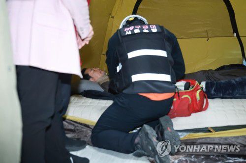 장동혁 대표 바이탈 체크하는 구급대원(서울=연합뉴스) 신현우 기자 = 21일 국회 로텐더홀 단식 농성장에서 구급대원이 통일교·공천헌금 '쌍특검' 수용을 요구하며 이레째 단식 중인 국민의힘 장동혁 대표의 바이탈을 체크하고 있다. 2026.1.21 nowwego@yna.co.kr