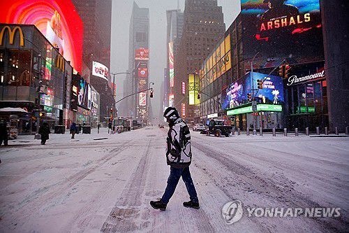 눈 내린 뉴욕 타임스퀘어(로이터=연합뉴스) 25일(현지시간) 눈폭풍 영향권에 든 미국 뉴욕 타임스퀘어 광장을 한 시민이 걷고 있다. 2026.1.25