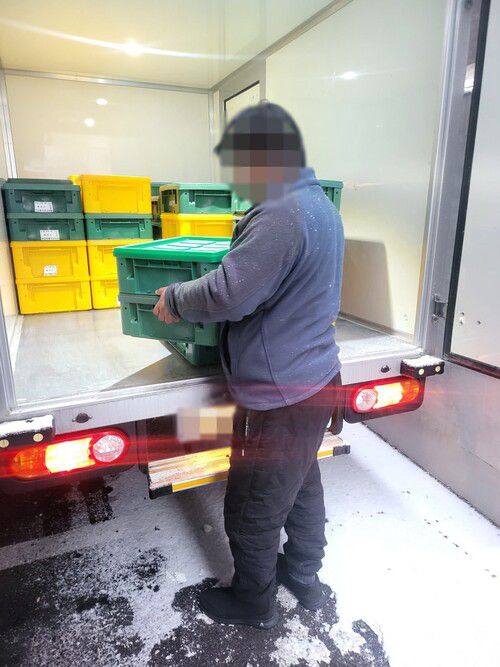 필자가 다회용기 식판을 수거해 배송하는 차량에서 식기 박스를 내리고 있다. 필자 제공