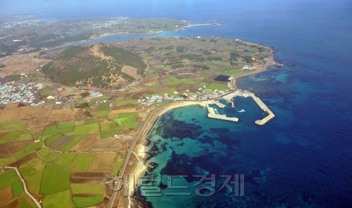 구좌읍 세화항구와 항구 왼쪽 솟아 오른 오름. 김명섭 기자.