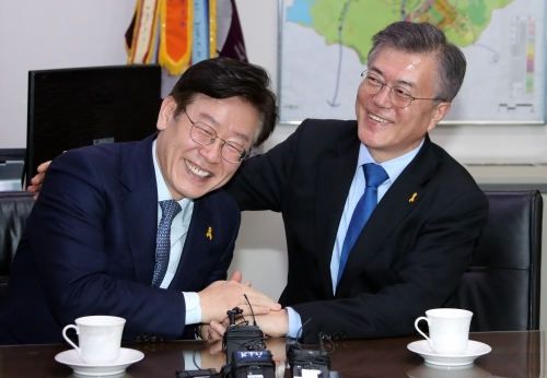 지난 2017년 4월 더불어민주당 19대 대선 후보 경선이 끝난 뒤 당시 민주당 문재인 대선후보(오른쪽)가 경기도 성남시청에서 후보 경쟁을 했던 이재명 시장을 만나 어깨를 다독이는 모습. 연합뉴스