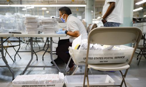 지난달 22일 뉴욕에서 보호 마스크를 쓴 선거관리위원회 직원이 보안 시설에 있는 USPS 통에서 꺼낸 투표용지를 세고 있다. 뉴욕=AP연합뉴스