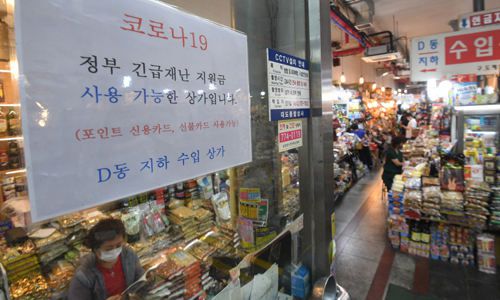 지난달 25일 서울 남대문시장 상가에 긴급재난지원금 사용가능 안내문이 붙어 있다. 이제원 기자