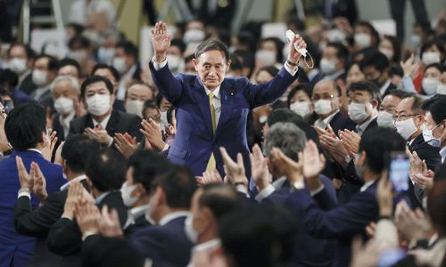 스가 요시히데 일본 관방장관이 14일 도쿄 한 호텔에서 열린 집권 자민당 총재 선거에서 경쟁 후보들을 압도적인 표 차로 제치고 총재에 당선된 뒤 손을 들어 환호에 답하고 있다. 도쿄=교도연합뉴스