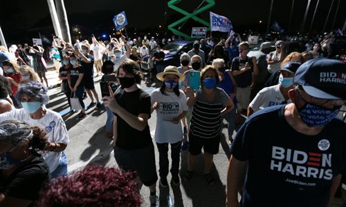 29일(현지시간) 플로리다 주 탬파에서 열린 플로리다 주 박람회장에서 열린 드라이브인 집회에서 조 바이든 민주당 대선 후보가 연설하는 모습을 보기 위해 무대 근처에 지지자들이 모여들고 있다. 탬파=AP연합뉴스