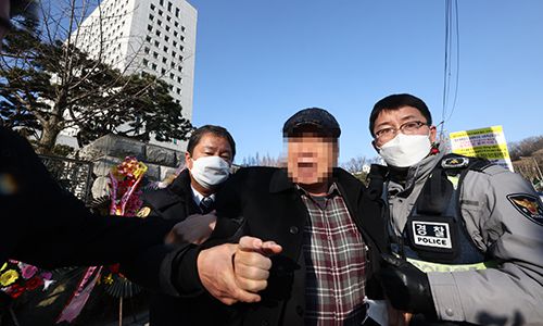 5일 오전 서울 서초구 대검찰청 앞에서 윤석열 검찰총장 응원화환에 불을 붙인 남성이 경찰에 연행되고 있다. 연합뉴스