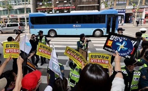 생후 16개월 입양아 정인 양을 학대해 숨지게 한 혐의를 받는 양부모의 1심 선고공판이 열린 지난 14일 오전 서울 양천구 서울남부지법 앞에서 시민들이 양모 장씨가 탄 것으로 보이는 호송차를 향해 피켓을 들고 항의하고 있다. 연합뉴스