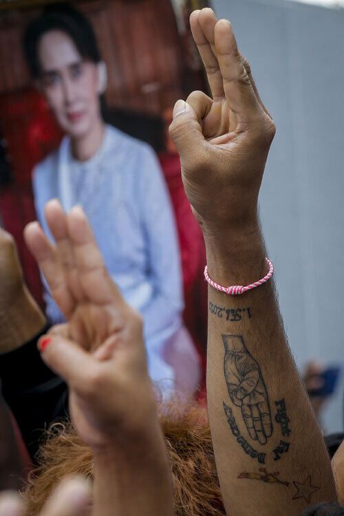 지난 1일 태국에 거주하는 노동자 등 미얀마 주민들이 방콕 주재 미얀마대사관 앞에서 아웅산 수치 국가고문의 사진을 든 채 저항을 뜻하는 손가락 3개를 펴 항의하고 있다. 방콕=EPA연합뉴스