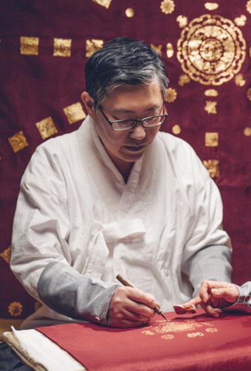 금박장 김기호 씨가 옷감에 금박을 새기고 있다. 문화재청 제공
