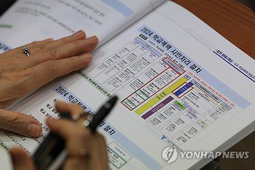 학교폭력 전담 조사관 역량강화 연수에 참여한 한 조사관이 안내 책자를 읽고 있다.