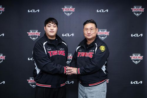 불펜 투수 조상우(왼쪽)가 21일 광주 기아챔피언스필드에서 원소속팀인 프로야구 KIA 타이거즈와 자유계약선수(FA) 계약을 맺은 뒤 심재학 KIA 단장과 악수하고 있다.