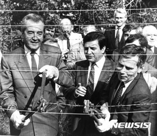 【빈=AP/뉴시스】 러시아와 국경을 맞댄 북·동유럽 북대서양조약기구(NATO·나토) 회원국들이 일제히 대인지뢰 사용을 금지하는 '오타와 협약' 탈퇴를 결정했다. 러시아와 전쟁 중인 우크라이나도 오타와 협약 탈퇴 결정을 공식 선언하면서, 유럽은 러시아와의 접경 지대 전역에 지뢰를 매설할 수 있게 될 전망이다. 사진은 알로이스 모크 전 오스트리아 외무장관(왼쪽)과 줄라 호른 헝가리 외무장관이 1989년 6월27일 양국간 국경에 설치된 철조망을 제거하는 모습. 2025.07.01.