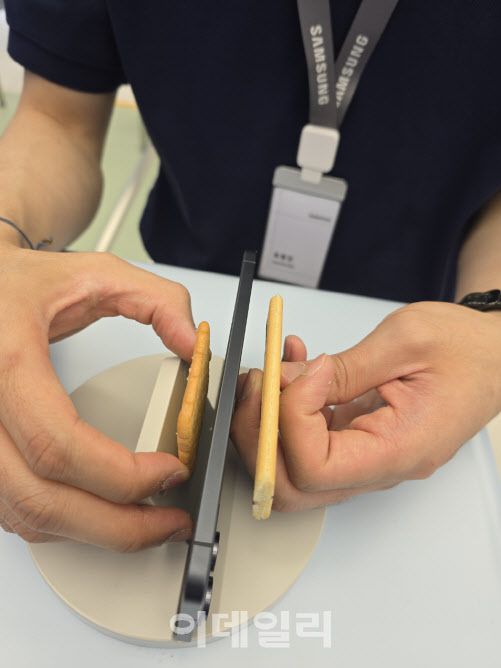 갤럭시 S25 엣지를 에이스(좌), 쿠크다스(우)와 두께를 비교하고 있다(사진=윤정훈 기자)