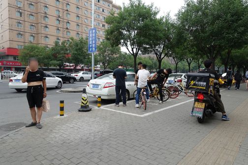 2019년 7월 19일 중국 베이징의 길거리에서 한 남성이 검은색 티셔츠를 가슴 부분까지 올리고 배를 드러낸 채 전화 통화를 하고 있다. /베이징=김남희 특파원