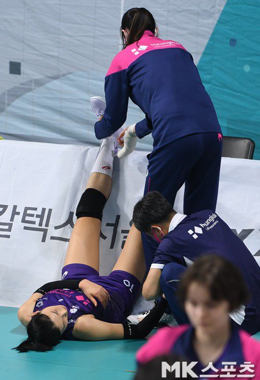 김세영이 깁스한 손으로 지친 김연경의 신발끈을 풀어주고 있다.