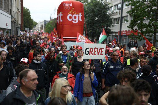 18일 프랑스 북부 릴에서 노동총동맹(CGT) 깃발을 든 시위대가 ‘파업’이라고 적힌 팻말을 들고 거리 행진을 하고 있다.(사진=AFP)