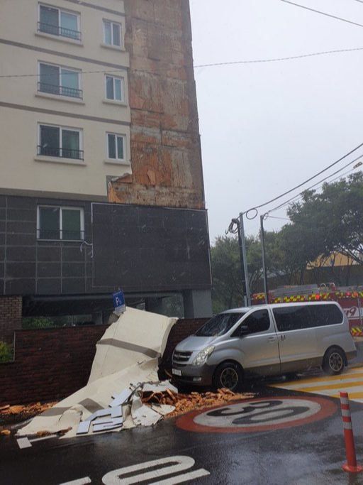 제8호 태풍 ‘바비’가 제주를 강타한 26일 오후 제주시 이도2동 한 아파트 외벽 마감재가 떨어져 주차된 차량을 덮치고 있다. 제주도 소방안전본부 제공
