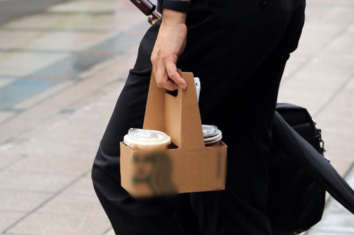 한 직장인이 28일 서울 시내의 한 프랜차이즈 카페에서 커피를 포장(테이크아웃) 후 걸어가고 있다. 뉴시스