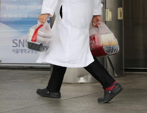 지난 6일 서울 종로구 서울대병원에서 의료진이 양손에 도시락을 들고 이동하고 있다. 뉴스1