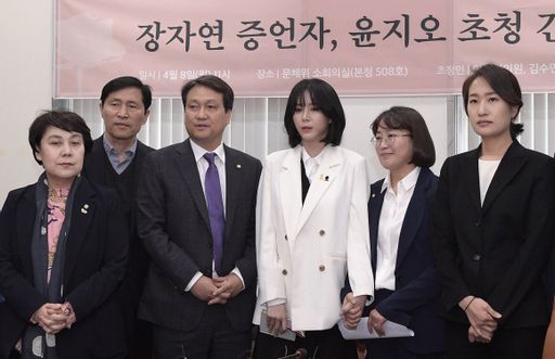 2019년 4월 8일 국회 소회의실에서 열린 ‘장자연 증언자, 윤지오 초청 간담회’에 참석해 윤지오 씨가 사진촬영을 하고 있다. 왼쪽부터 당시 민주당 정춘숙·이학영·안민석 의원, 윤씨, 정의당 추혜선·바른미래당 김수민 의원. 연합뉴스