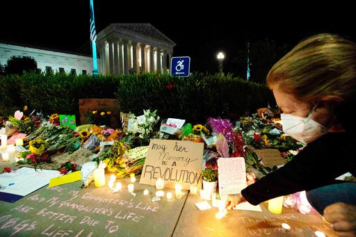 약자를 대변하는 목소리로 미국 진보 진영의 상징인 루스 베이더 긴즈버그 연방대법관이 18일(현지시간) 별세하자 다음날 워싱턴 대법원 청사 앞에 고인을 추모하는 꽃다발과 촛불, 메시지 카드 등이 가득 놓여 있다. 워싱턴=AFP연합뉴스
