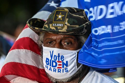 미국 대선 하루 전인 2일(현지시간) 민주당 후보 조 바이든 전 부통령을 지원하기 위해 버락 오바마 전 대통령이 참석한 플로리다주 마이애미의 드라이브인 유세장에서 한 전역 군인이 바이든 대통령 후보와 카멀라 해리스 부통령 후보 지지 마스크를 쓰고 연설을 경청하고 있다. 마이애미 AFP=연합뉴스